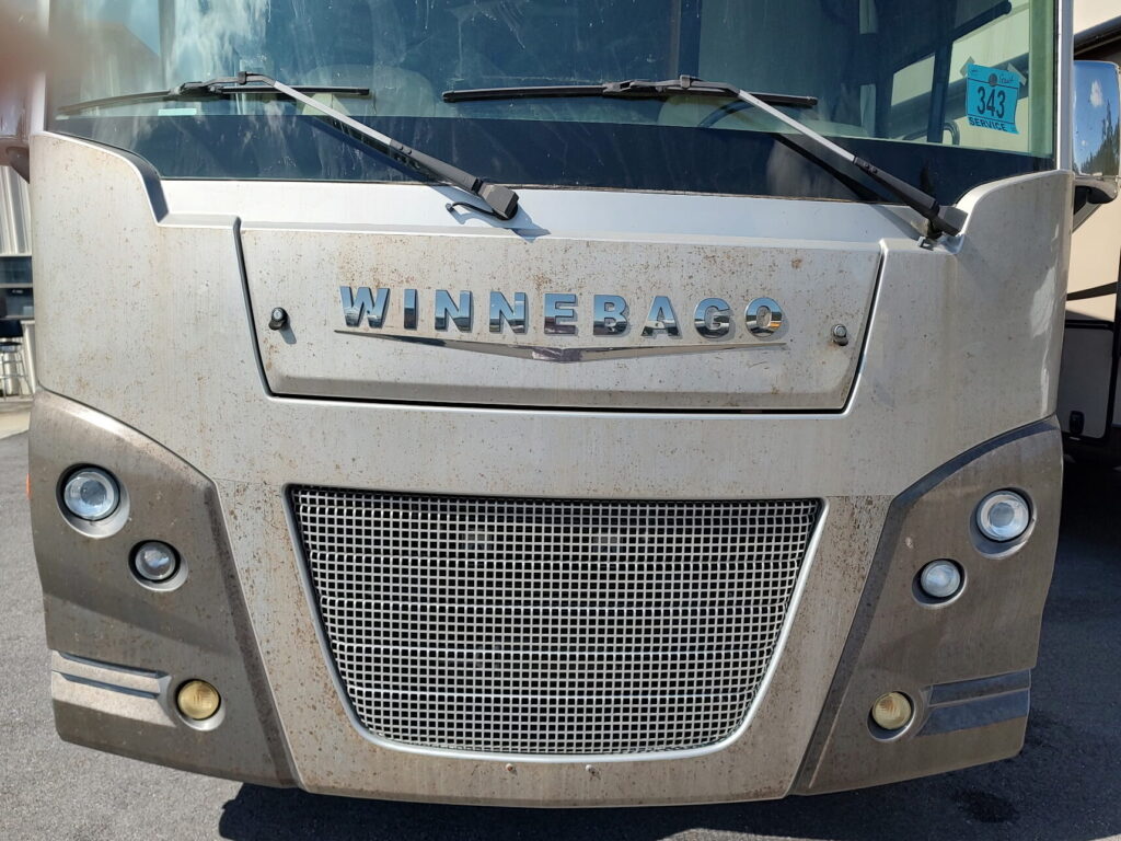 Before of a photo of RV front showing dirty Diamond Shield before color-matched bed liner applied.